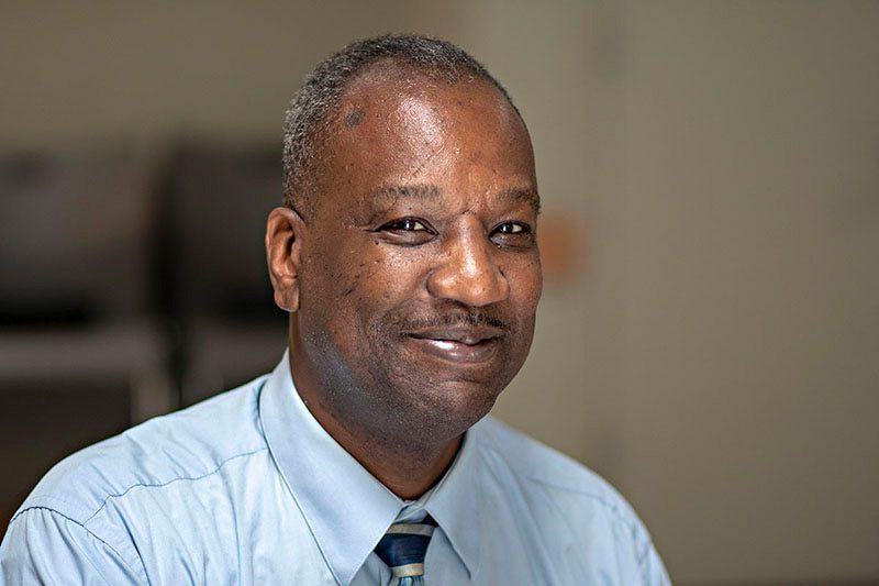 Man with short hair smiling indoors