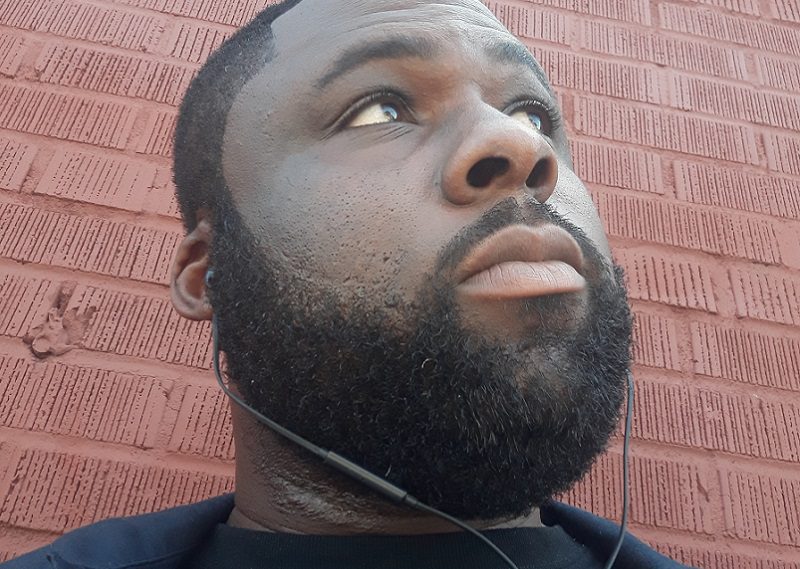 Bearded man in front of red brick wall